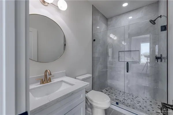 a bathroom with a sink a toilet and a mirror