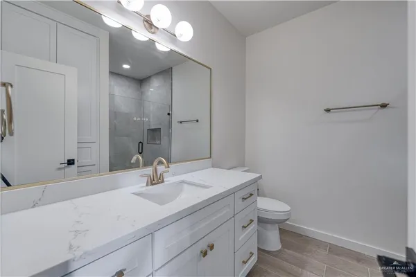 a bathroom with a sink mirror vanity and toilet