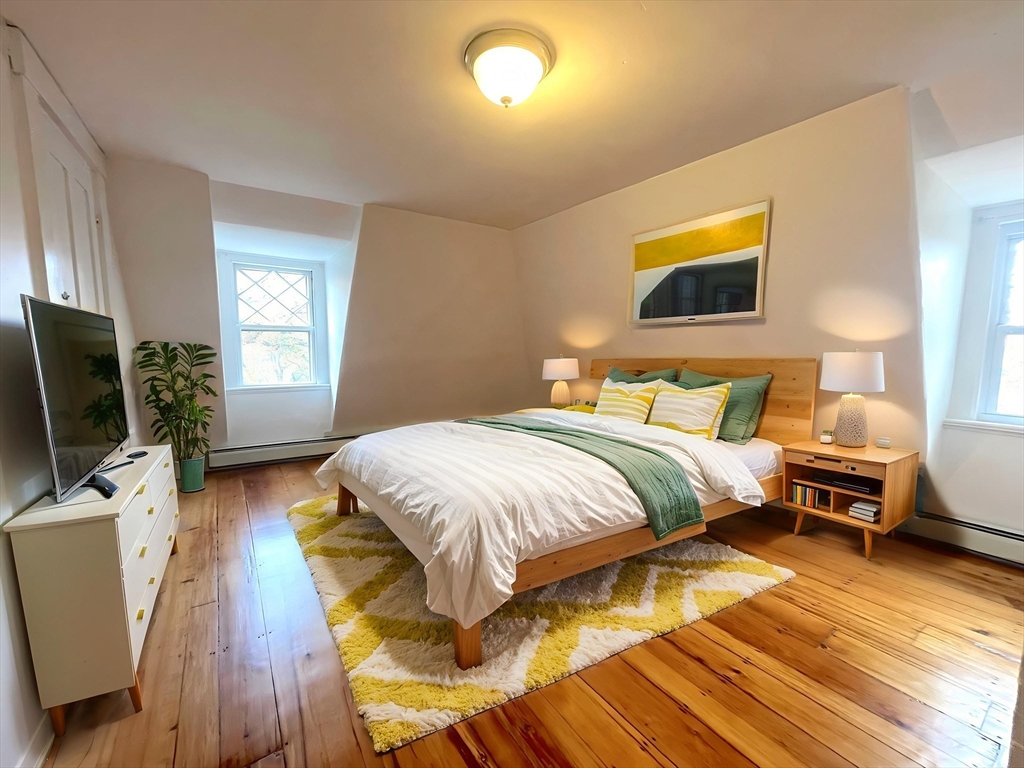 156 Park Street, Unit 3 Newton, MA 02458 - Photo 3 of 10 a bedroom with a bed and wooden floor