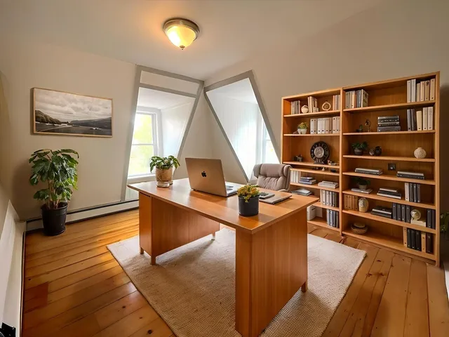 a view of a workspace with furniture and wooden floor