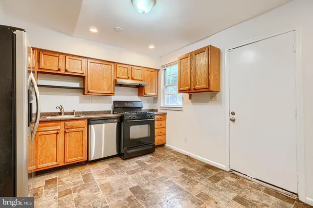 a kitchen with stainless steel appliances granite countertop a refrigerator and a stove top oven