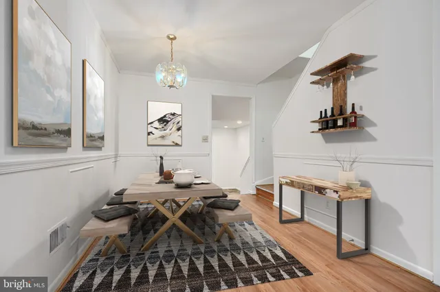 a view of a dining room with furniture a chandelier and wooden floor