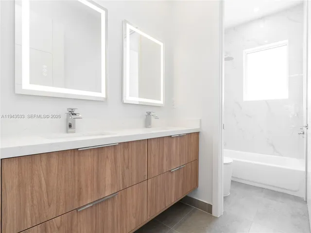 a bathroom with a sink a mirror and a bathtub