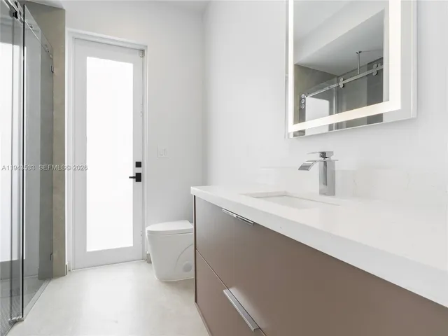 a bathroom with a sink a toilet and a mirror