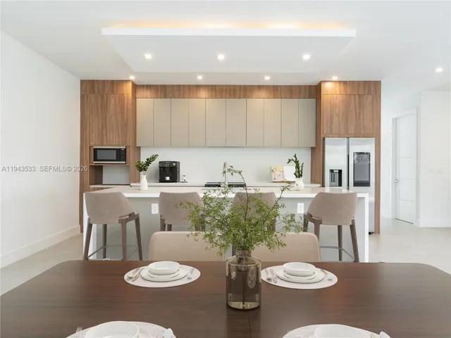 a kitchen with a white table and chairs