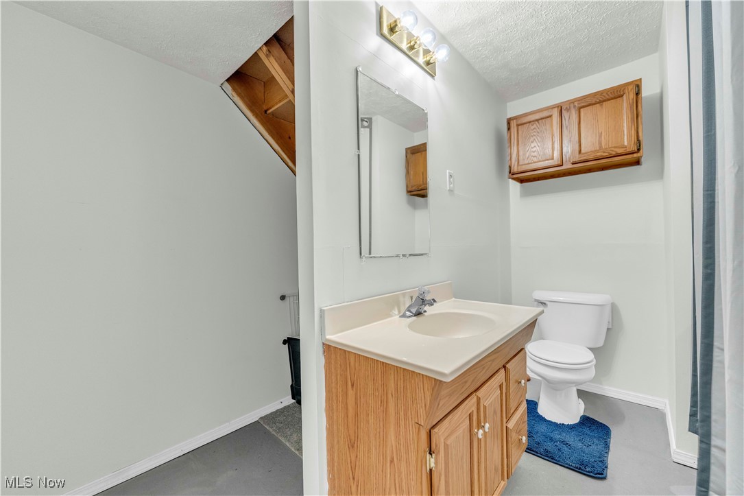8110 Risden Road Vermilion, OH 44089 - Photo 20 of 48 Bathroom featuring vanity, a textured ceiling, and toilet