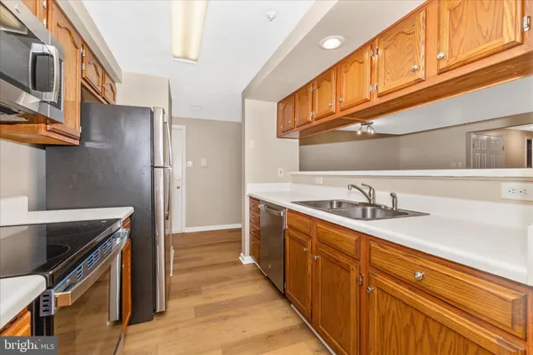 a kitchen with stainless steel appliances granite countertop a sink and a refrigerator