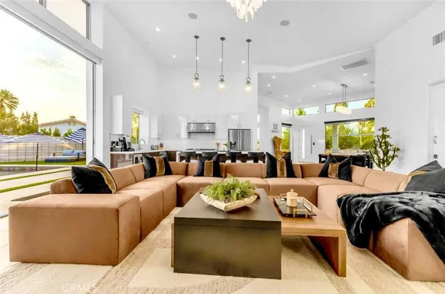 a large kitchen with stainless steel appliances a stove center island a living room and a couch