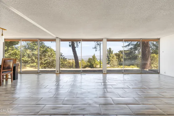 a view of empty room with wooden floor and city view