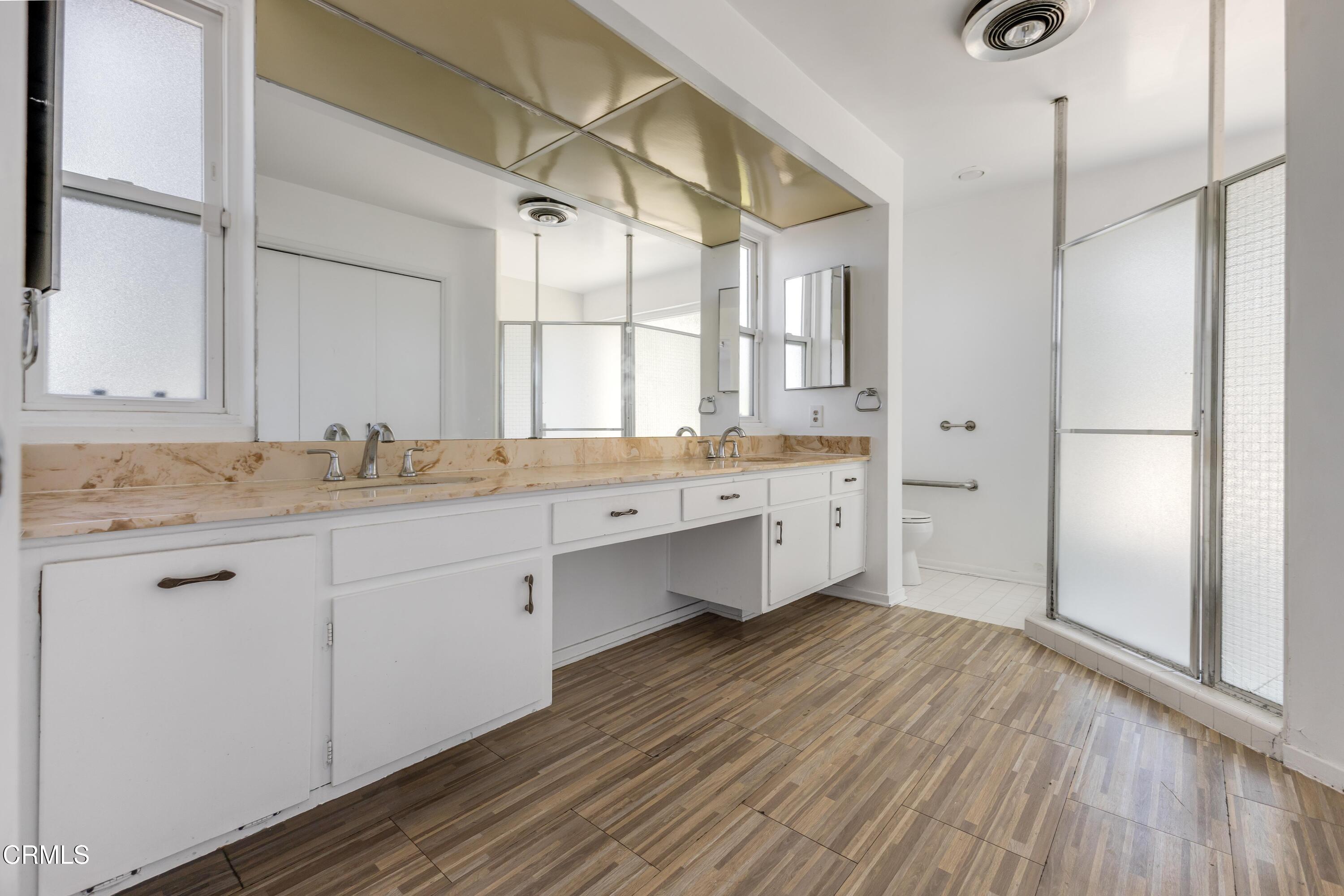 16274 Dorilee Lane Encino, CA 91436 - Photo 11 of 23 a spacious bathroom with a granite countertop sink mirror and a shower