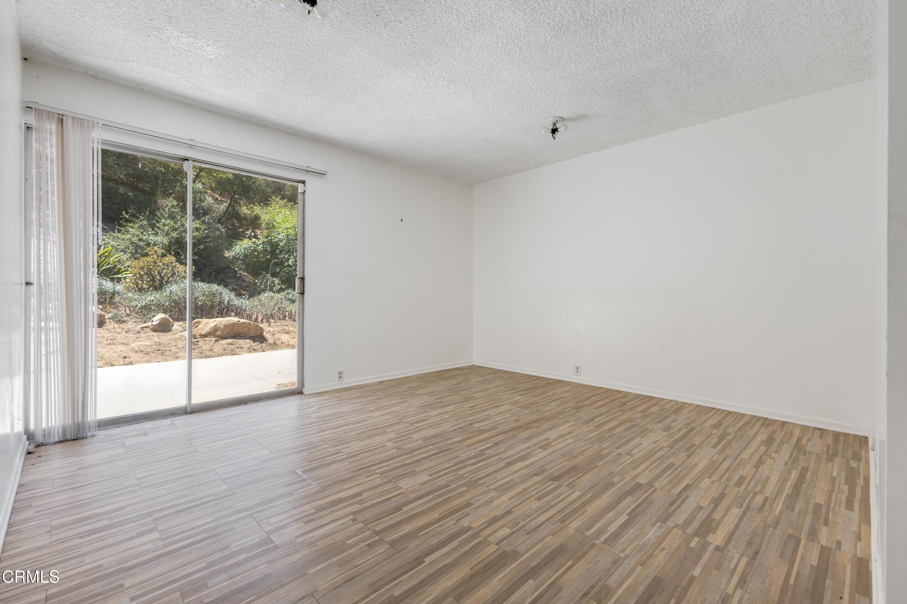 16274 Dorilee Lane Encino, CA 91436 - Photo 12 of 23 a view of an empty room with wooden floor and a window