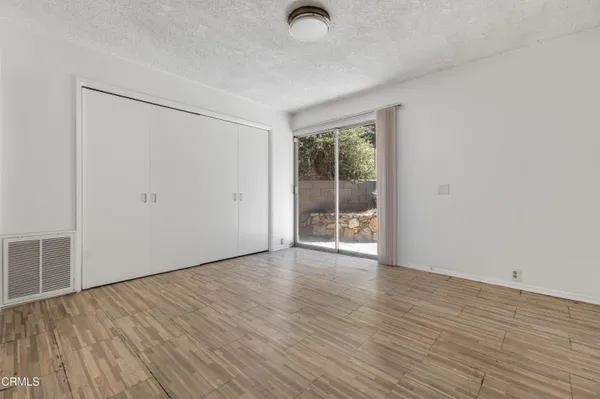 an empty room with wooden floor and windows