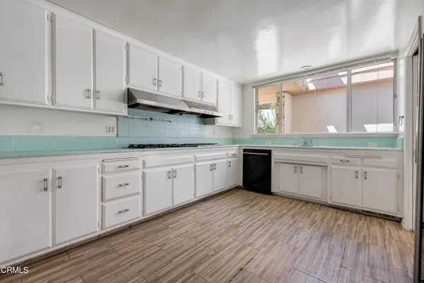 a white kitchen with granite countertop stainless steel appliances