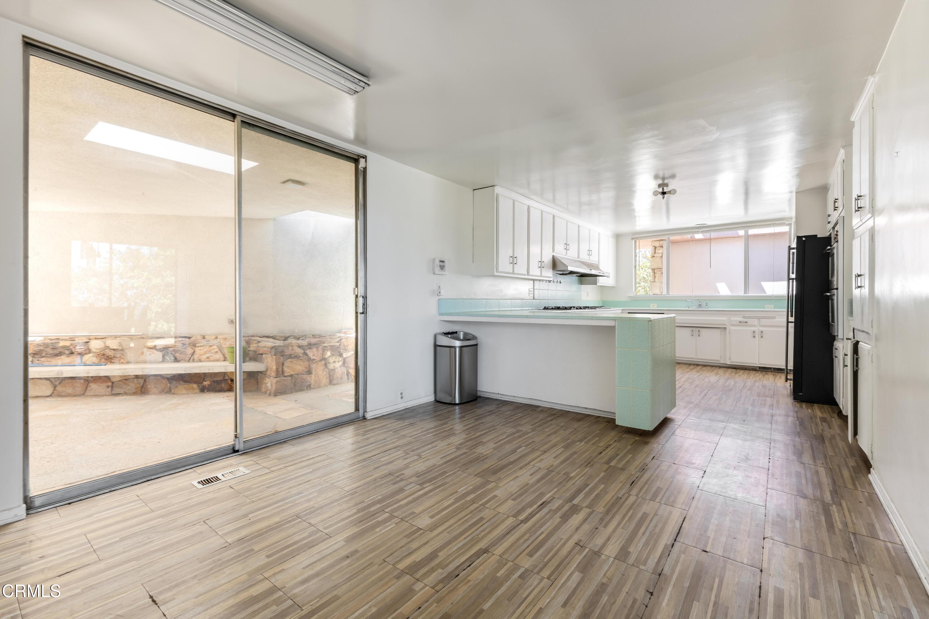 16274 Dorilee Lane Encino, CA 91436 - Photo 8 of 23 a kitchen with stainless steel appliances wooden floor and a large window