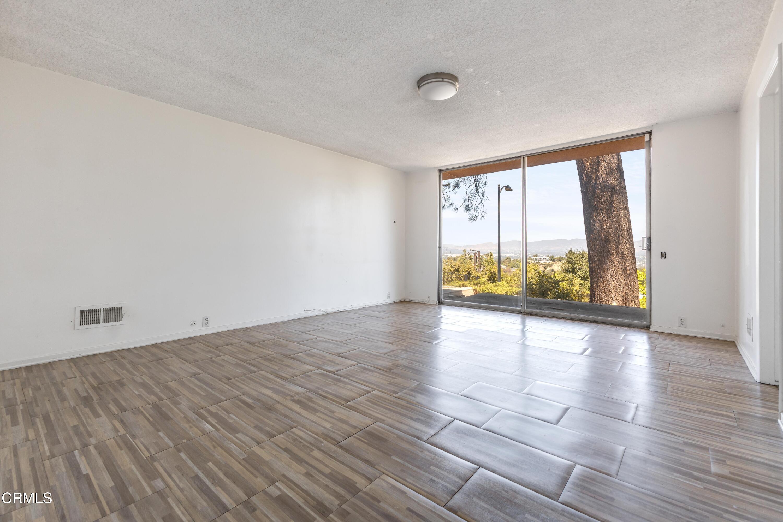 16274 Dorilee Lane Encino, CA 91436 - Photo 9 of 23 wooden floor in an empty room with a window