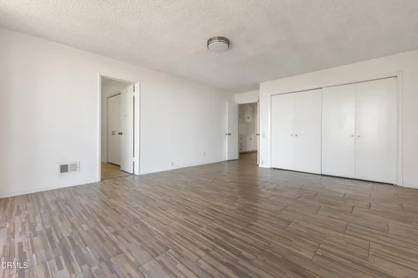 a view of an empty room with wooden floor