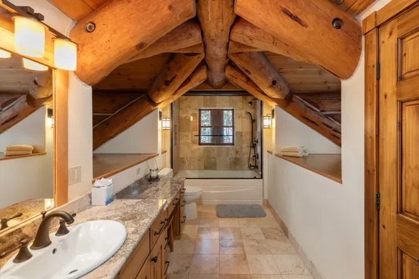 a bathroom with a granite countertop sink and washing machine