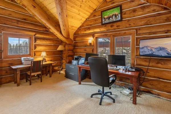 a view of a workspace with furniture and a window