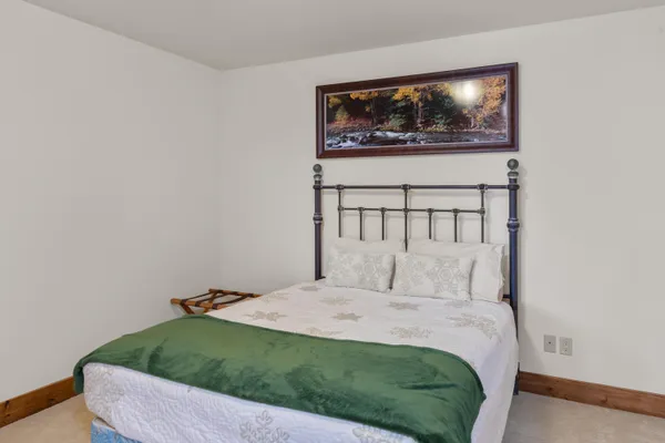 a bedroom with a bed and a painting on the wall