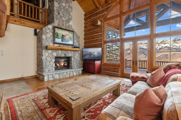 a living room with a couch a rug kitchen view and a fireplace