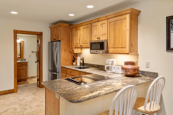 a kitchen with stainless steel appliances granite countertop a sink refrigerator and cabinets