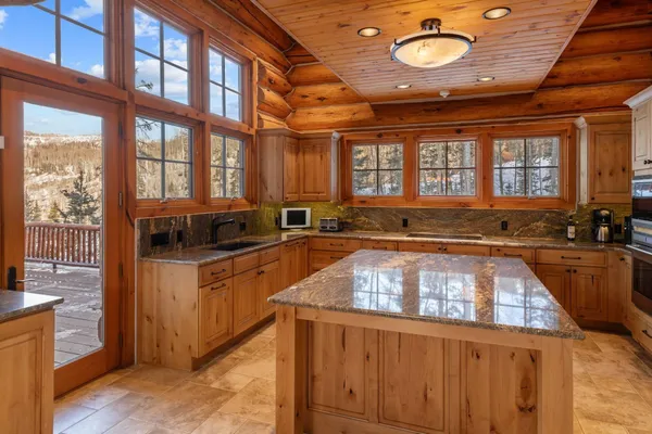 a large kitchen with stainless steel appliances granite countertop a stove and a sink