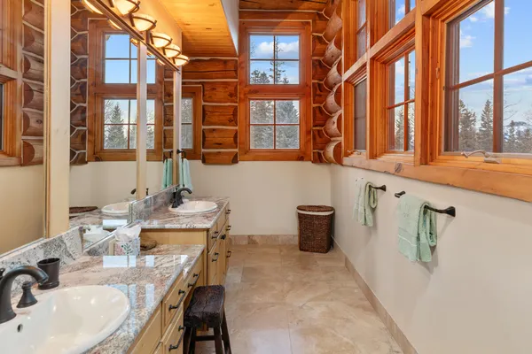 a bathroom with a granite countertop sink and a large mirror