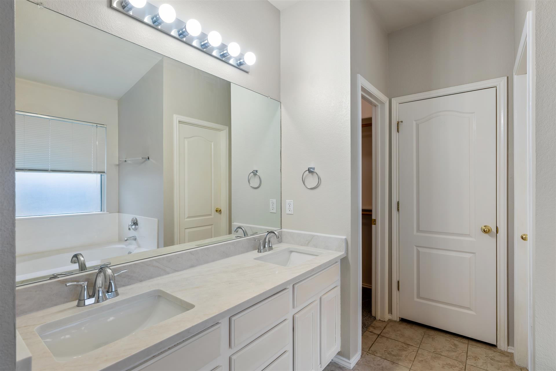 4725 Tello Path Austin, TX 78749 - Photo 20 of 34 Double vanity sinks and a soaking tub create a restful primary bath oasis.