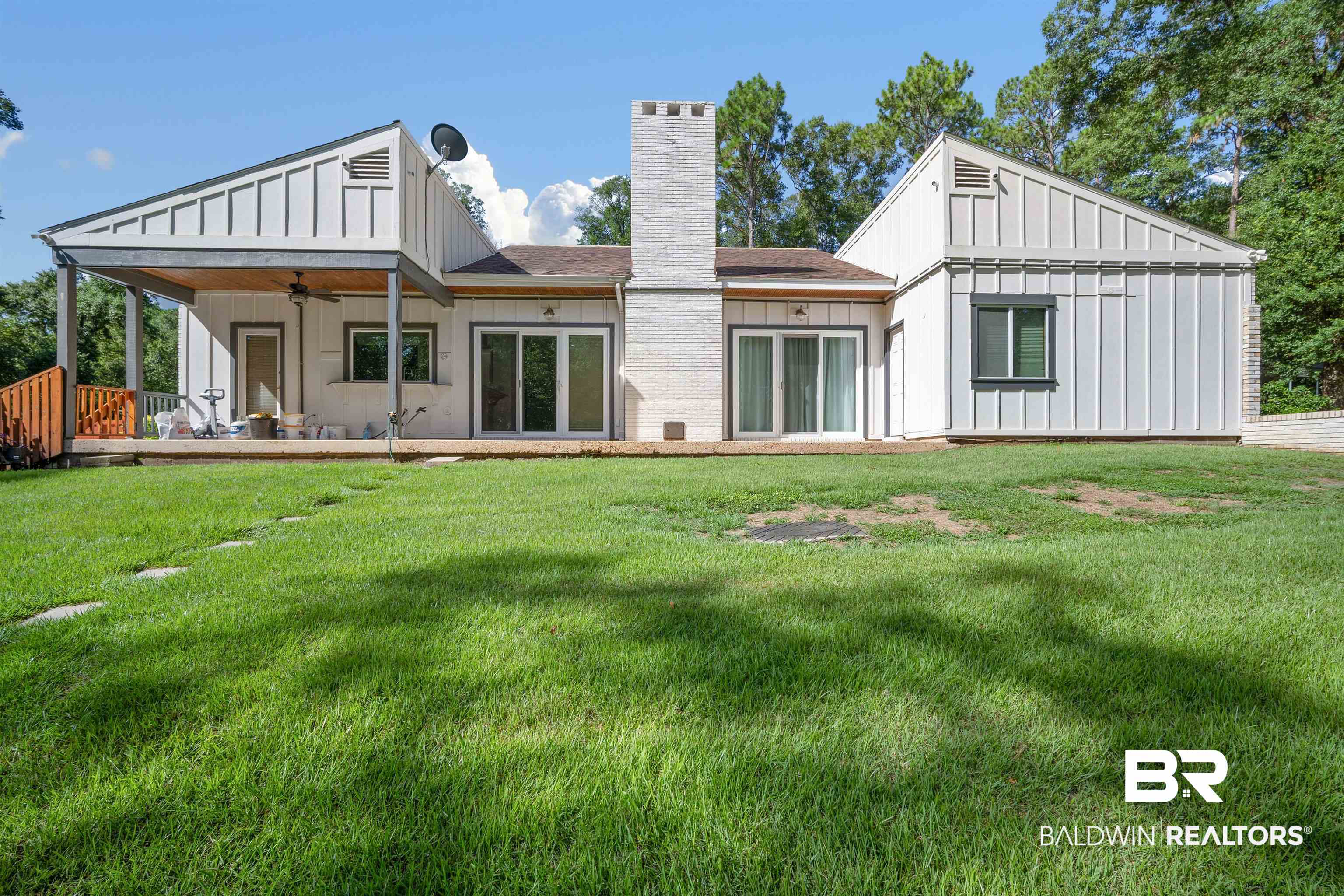 7912 Yorkhaven Road Mobile, AL 36695 - Photo 28 of 41 Rear view of property featuring a ceiling fan, a lawn, board and batten siding, and a chimney
