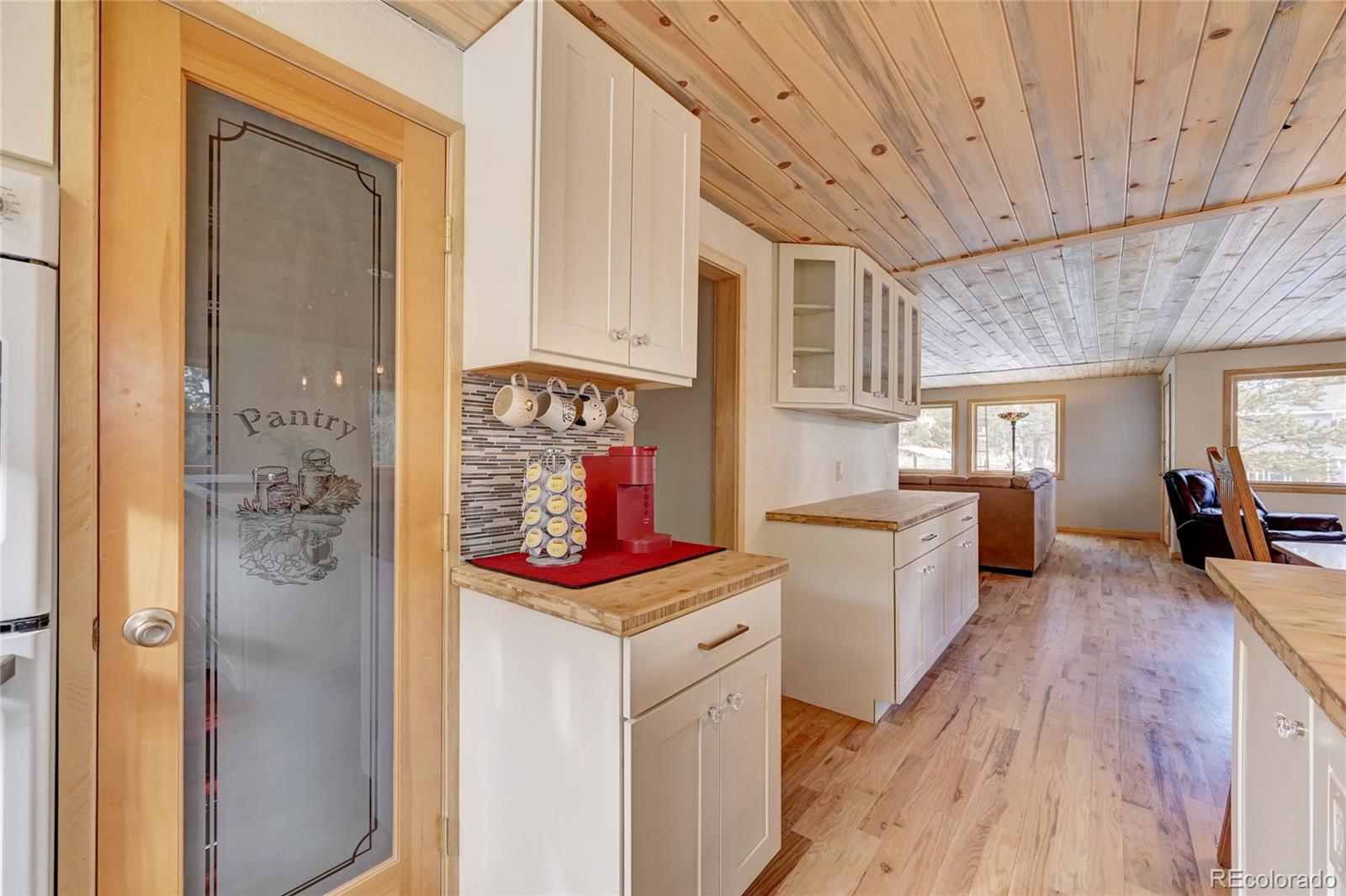 526 Rising Sun Road Bailey, CO 80421 - Photo 13 of 40 a kitchen with a refrigerator a sink dishwasher with a dining table and chairs