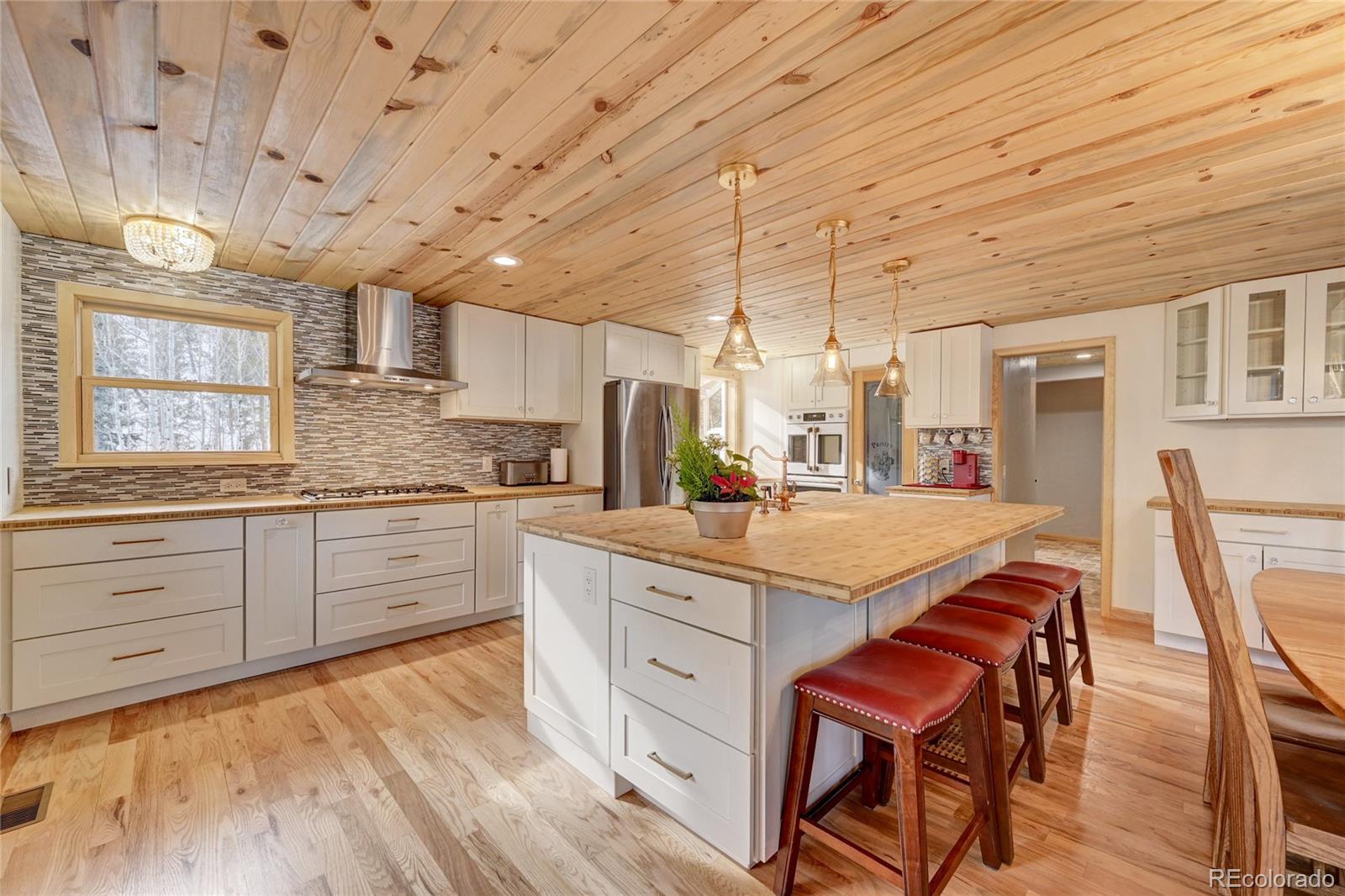 526 Rising Sun Road Bailey, CO 80421 - Photo 14 of 40 a kitchen with a white cabinets and chairs in it