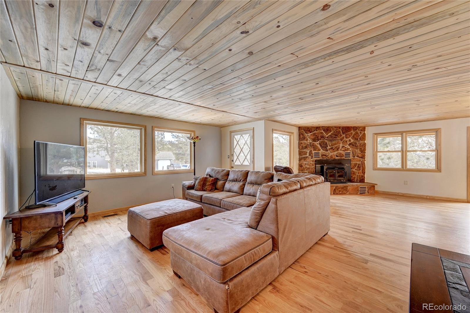 526 Rising Sun Road Bailey, CO 80421 - Photo 20 of 40 a living room with furniture large window and a flat screen tv