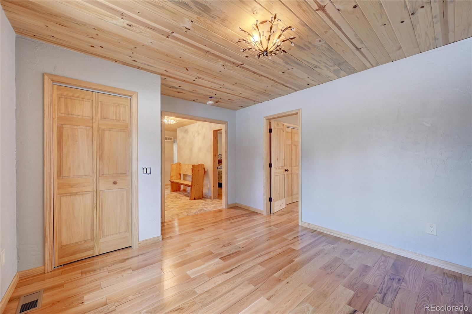 526 Rising Sun Road Bailey, CO 80421 - Photo 27 of 40 a view of hallway with a chandelier fan and wooden floor
