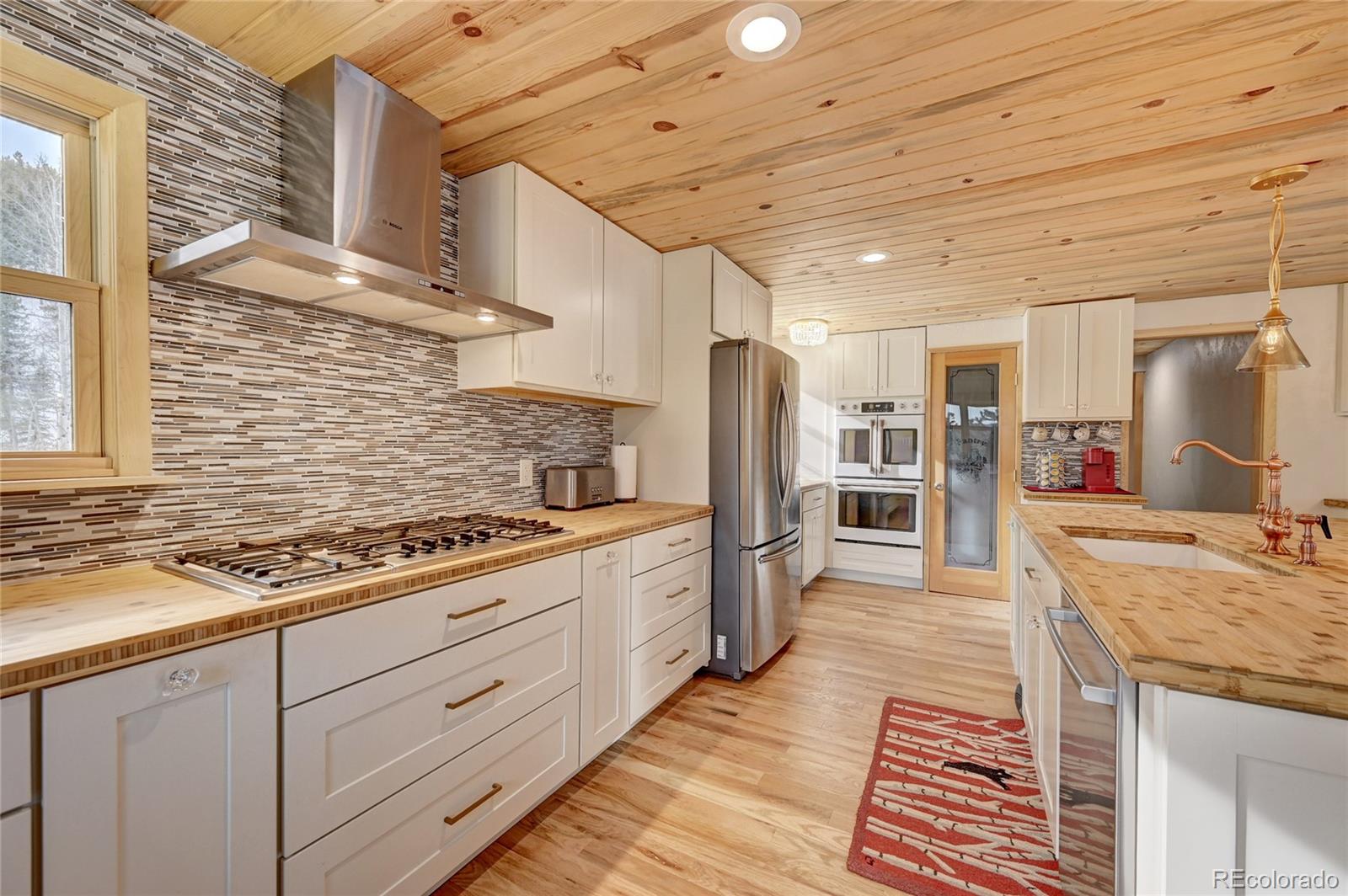 526 Rising Sun Road Bailey, CO 80421 - Photo 4 of 40 a kitchen with stainless steel appliances granite countertop a stove a sink and a refrigerator