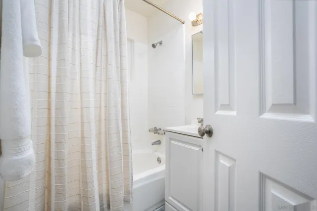 a bathroom with a sink a toilet and shower curtain