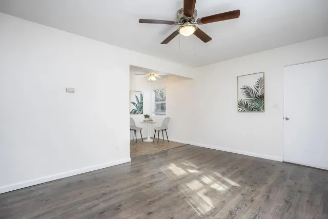 a view of a livingroom with a hardwood floor and a ceiling fan