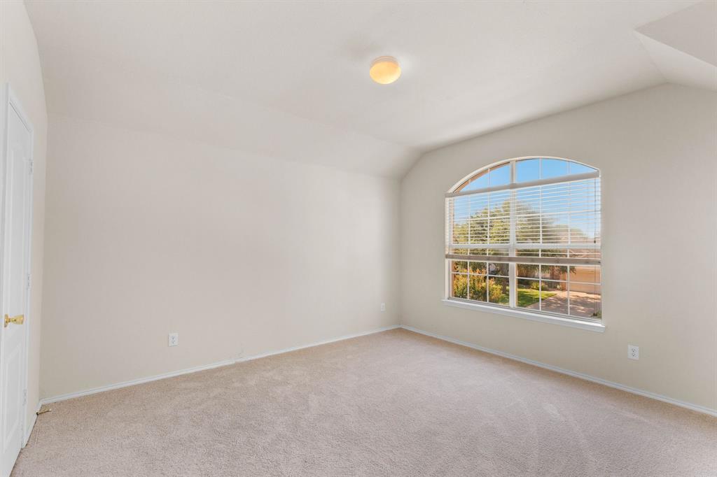 2700 Hereford Road Denton, TX 76210 - Photo 22 of 36 Room featuring an arched window with blinds, neutral carpeting, light-toned walls, and a ceiling-mounted light fixture