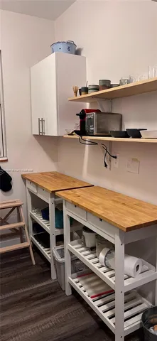 a view of kitchen with wooden floor and cabinets