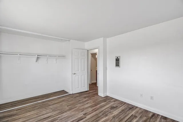 a view of an empty room with wooden floor