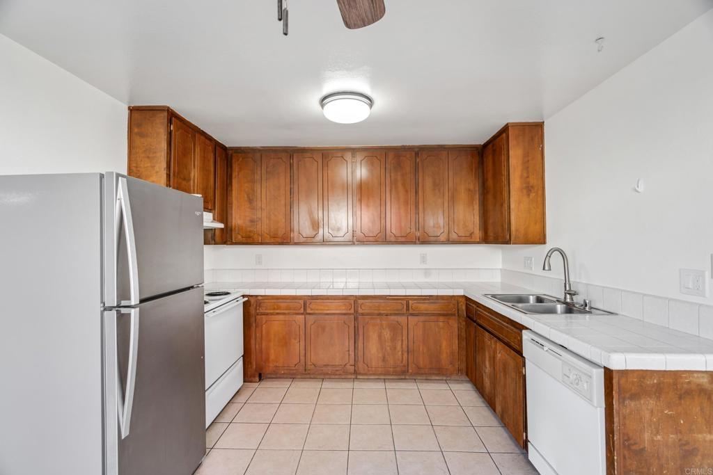 2964 Crane Street, Unit A B Lemon Grove, CA 91945 - Photo 25 of 50 a kitchen with stainless steel appliances granite countertop a refrigerator a sink and dishwasher