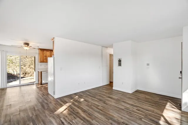 a view of a room with wooden floor and a window