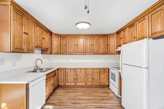 a kitchen with a sink a refrigerator and cabinets