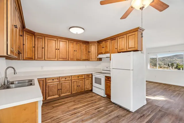 a kitchen with wooden cabinets and white appliances