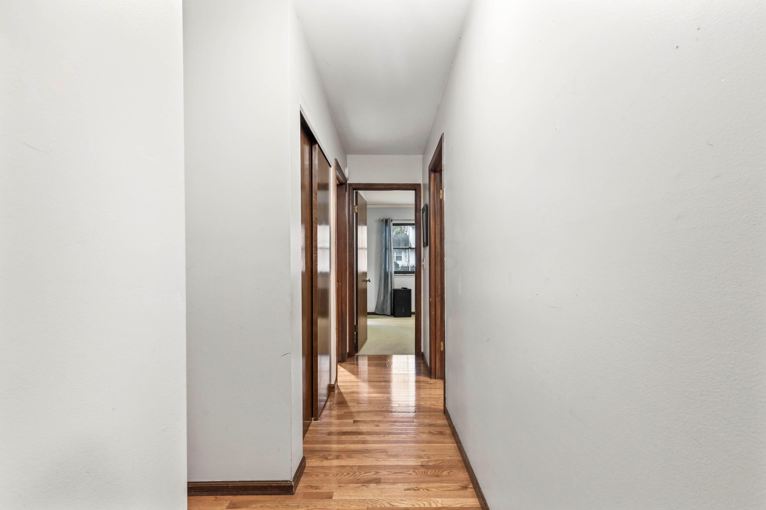7020 Rieber Street Columbus, OH 43085 - Photo 22 of 40 • New hardwood flooring • Grey painted walls • Ceiling light • Closet with double sliding doors • 2” blinds