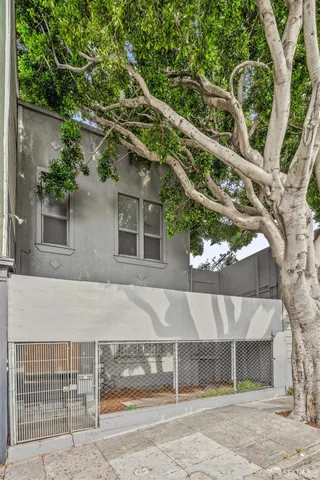 a view of a house with a tree and wooden fence
