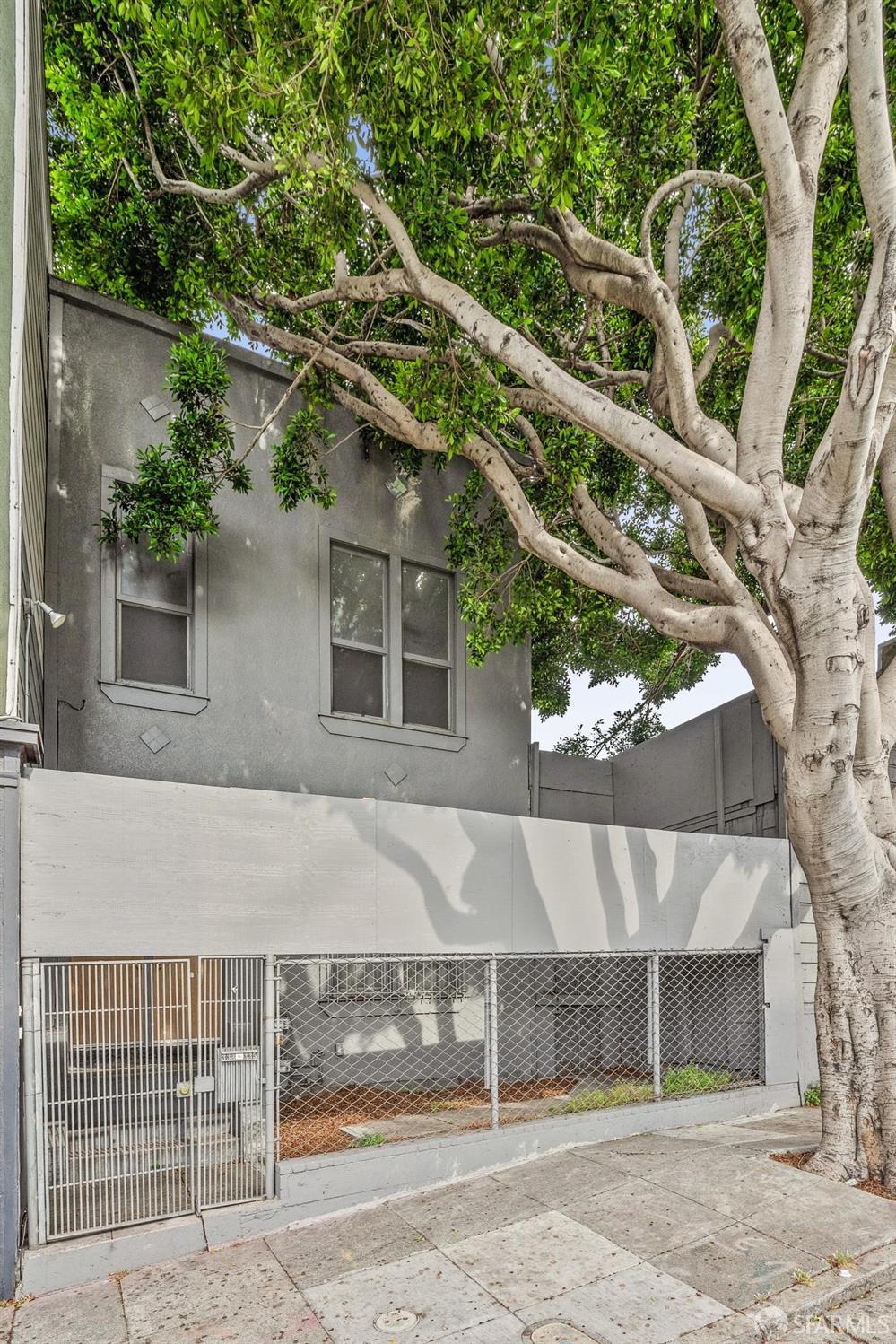 a view of a house with a tree and wooden fence