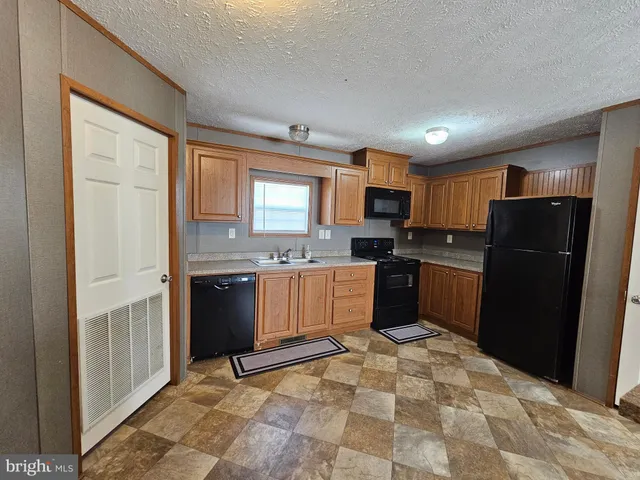 a kitchen with granite countertop a refrigerator and a sink