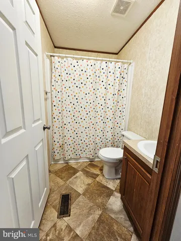 a bathroom with a toilet and a shower curtain