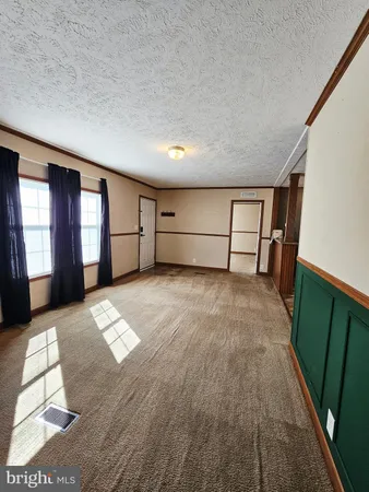 a view of empty room with windows and wardrobe