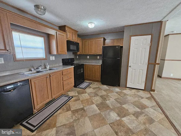 a kitchen with a refrigerator sink and wooden cabinets